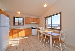 Kitchen with dining table and 3 chairs, oven, and sink