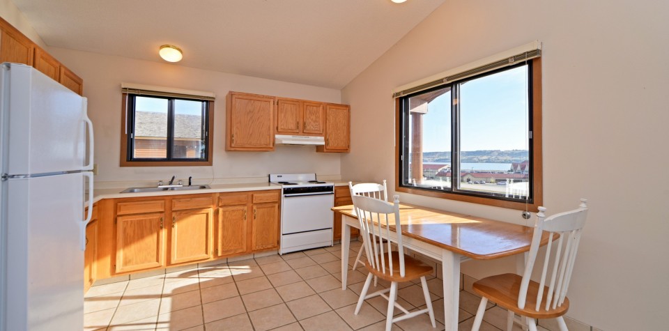 Kitchen with dining table and 3 chairs, oven, and sink